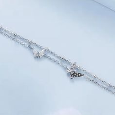 Add a touch of elegance to your style with our Butterflies double chain bracelet! Made from high-quality sterling silver, this bracelet features delicate butterfly charms that will flutter on your wrist. Perfect for any occasion, it's a must-have accessory for any butterfly lover. Materials: 925 sterling silver, cubic zirconiaFinish: platinum plateChain length: 6 in + 2 in adjustable chain Jewelry Care: See more information about how to care for your jewelry here. Shipping Policy: Orders will be shipped within 1-3 business days. Economy shipping will take 7-14 days to arrive and standard shipping is 1- 4 days for U.S. orders. International shipping time is depended on the country and per shipping method. Shipping cost will be calculated at check out.For more details, see our Shipping Polic Silver Bracelet With Butterfly Clasp For Gift, Trendy Adjustable Silver Butterfly Necklace, Elegant Silver Butterfly Bracelets, Silver Dainty Butterfly Bracelets, Delicate Sterling Silver Charm Bracelet, Butterfly-shaped Sterling Silver Bracelet, Silver Sterling Silver Butterfly Bracelet, Dainty Silver Butterfly Bracelets, Delicate Silver Charm Bracelet With Adjustable Chain