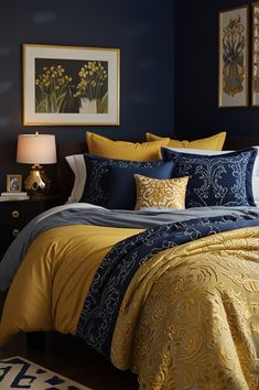 a bed with yellow and blue comforters in a bedroom next to a painting on the wall