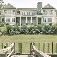 a large white house sitting on top of a lush green field