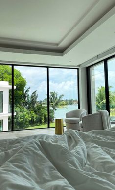 a bedroom with large windows overlooking the water