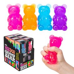 a hand holding a gummy bear in front of four different flavors of gummy bears