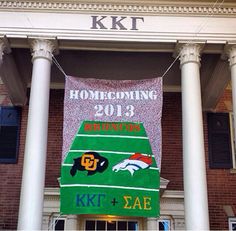 a large banner is hanging on the front of a brick building with columns and windows