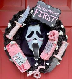 a wreath decorated with fake toothbrushes, telephones and a ghost mask on the front door