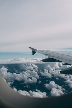 the wing of an airplane flying over clouds