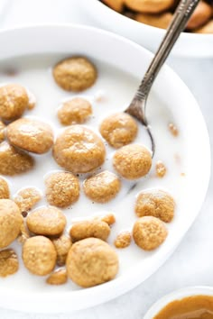 a white bowl filled with cereal and some kind of food on top of a table