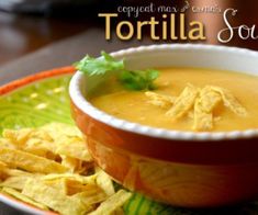 a bowl of tortilla soup with chips on the side