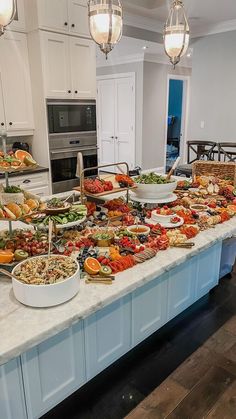 a large table filled with lots of food on top of a kitchen counter next to an oven