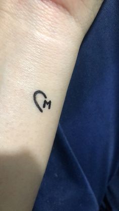 a small black arrow tattoo on the wrist