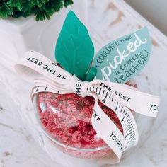 a glass bowl filled with candy and measuring tape