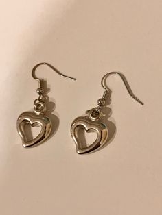 Adorable silver dangly heart earrings. cute y2k themed aesthetic earrings. Trendy Sterling Silver Heart Earrings For Everyday, Metal Dangle Heart Earrings With Heart Charm, Trendy Everyday Heart Dangle Earrings, Y2k Heart-shaped Valentine's Day Jewelry, Valentine's Day Y2k Heart Jewelry, Valentine's Day Heart-shaped Y2k Jewelry, Valentine's Day Heart Shaped Y2k Jewelry, Trendy Heart Charm Earrings, Trendy Silver Hoop Earrings With Heart Charm