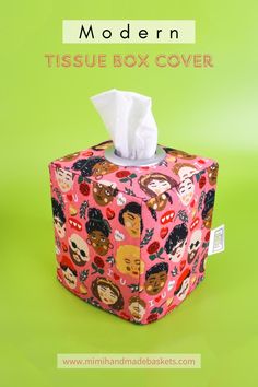 a tissue box covered in cartoon faces on a green background with the title modern tissue box cover