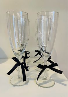 two clear wine glasses with black bows on the rims are sitting next to each other