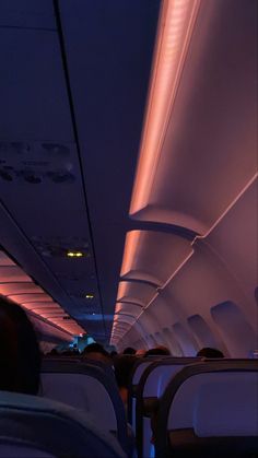 the inside of an airplane with people sitting in seats