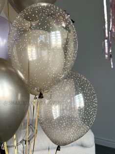 silver and white balloons with streamers hanging from the ceiling