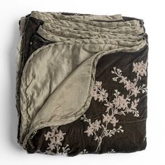 three blankets are folded on top of each other, with flowers and leaves printed on them