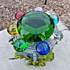 an image of a colorful object in the middle of some rocks and gravel with stones around it