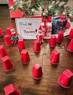 red plastic cups are sitting on the floor next to a christmas tree