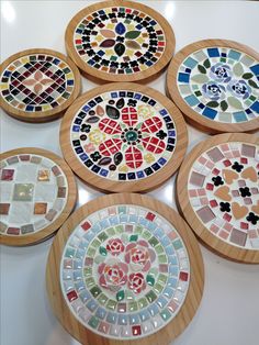 six wooden coasters with colorful designs on them sitting on a counter top next to each other