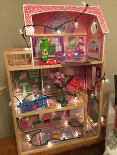 a doll house with lights and furniture inside