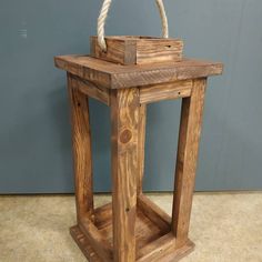 a wooden table with rope on top and a box in the middle that is holding something