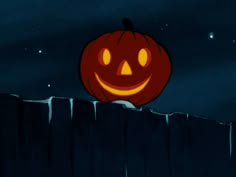 an animated pumpkin sitting on top of a wooden fence at night with the moon in the background