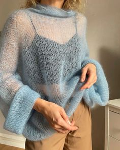 a woman wearing a blue sweater and tan pants