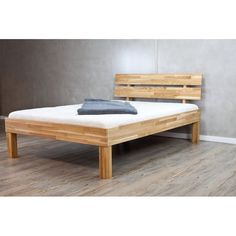 a bed frame made out of wood with a mattress on the bottom and headboard