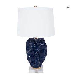 a blue ceramic lamp with a white shade on the base and a gold - plated metal base