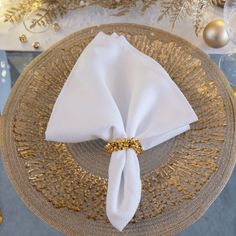 a white napkin is on top of a gold plate with a golden bow around it