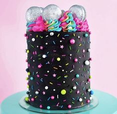 a black cake with sprinkles and balls on top