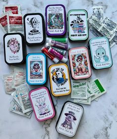 many different tins with various designs on them sitting on a marble surface next to each other