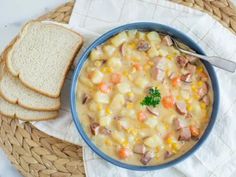 a bowl filled with soup next to slices of bread on top of a white towel