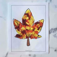 a leaf made out of tissue paper sitting on top of a table