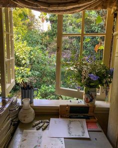 an open window in a room filled with lots of plants and papers on top of a table