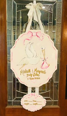 a plaque with a stork on it in front of a glass door that reads, mitchell & mayne's fancy shoes