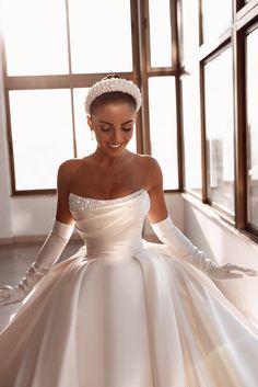 a woman in a white wedding dress and gloves