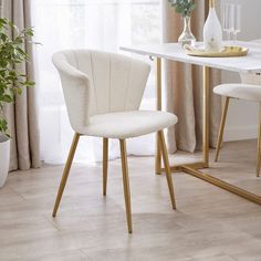 two white chairs sitting in front of a table