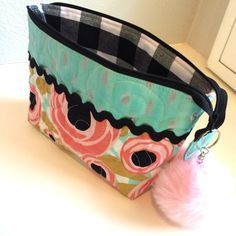 a purse with a pom - pom hanging from it