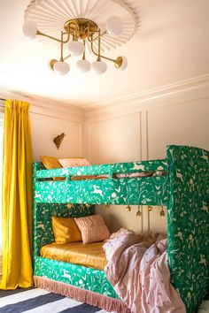 a green and yellow bunk bed sitting next to a window with curtains on the windowsill