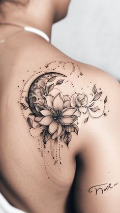 the back of a woman's shoulder with flowers and a half moon on it