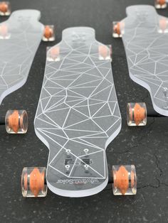 several skateboards are lined up on the ground, with orange wheels and spokes