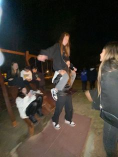 a group of young people standing around each other on a skateboard ramp at night