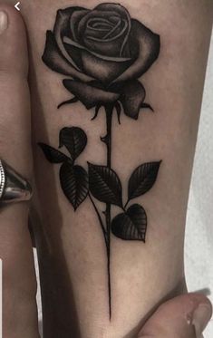 a black rose tattoo on the thigh