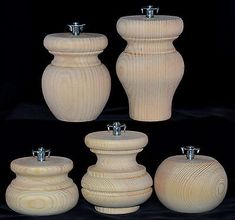 four wooden vases are shown on a black background