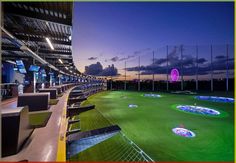 an indoor golf course at night with lights on