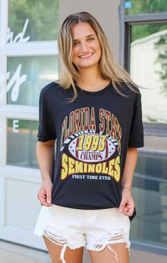 Can't get enough of our cozy FSU tees? Then you'll love our "1993 Forever" Vintage Boyfriend Tee! This black, crisp tee is perfect for alumni and current students alike. Rock this shirt at the next home game! Details: *OFFICALLY LICENSED* Vintage Washed Cotton Tee 100% Cotton Crew Neckline, Short Sleeve, Full Length Features Garnet & Gold FSU Lettering with 1993 in the middle, Center Chest Color: Black True to Size: Unisex, relaxed fit Jaden is wearing size Small Garment measurements in inches: Small = Bust: 17.5” / Length: 27.5” Medium = Bust: 18.5” / Length: 28.5” Large = Bust: 22 1/4” / Length: 29.5” X- Large = Bust: 22.5” / Length: 30” XX-Large = Bust: 23 3/4” / Length: 31” Have questions about sizing, fit, or styling? Send us a chat or give us a call at 850-629-4890 during business ho College Style Crew Neck T-shirt For College Events, Black School Spirit T-shirt With Slogan, Graphic Tee For College Events, 90s Style Short Sleeve T-shirt For Game Day, Graphic Tee T-shirt For College Events, Casual Black Tops For College Events, Graphic Tee With Text Print For College Events, Collegiate Style Black T-shirt For College Events, Black T-shirt For College Events