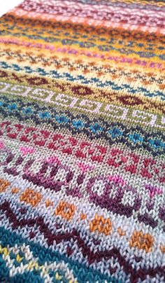 a multicolored knitted area rug is shown