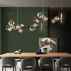 a dining room table with chairs and lights hanging from the ceiling