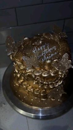 there is a cake that has been decorated with gold and white frosting on it