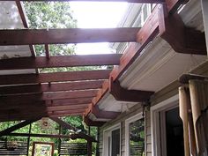 the porch is covered with wooden slats and has an attached pergolated roof